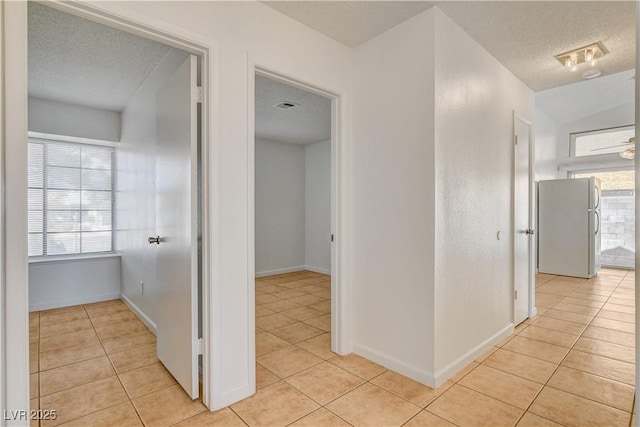 6521 Faith Peak Dr, Las Vegas, NV 89108 - hall featuring a textured ceiling, light tile patterned flooring, plenty of natural light, and baseboards