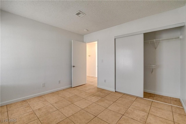 6521 Faith Peak Dr, Las Vegas, NV 89108 - unfurnished bedroom featuring light tile patterned floors, a textured ceiling, a closet, and baseboards