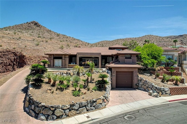 205 Red Rock Rd, Boulder City, NV 89005 - prairie-style house with a mountain view, concrete driveway, stucco siding, and a tile roof