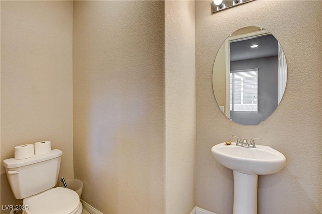 9846 Sunriver Meadows Ave, Las Vegas, NV 89148 - half bathroom with toilet, a sink, and baseboards