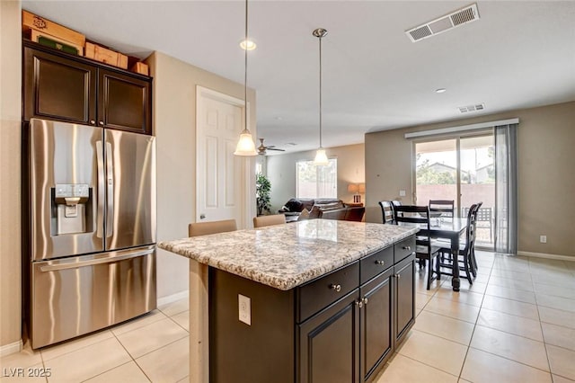 9846 Sunriver Meadows Ave, Las Vegas, NV 89148 - kitchen with stainless steel fridge, light tile patterned floors, baseboards, pendant lighting, and a kitchen island