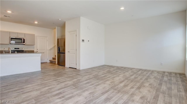 4229 Venus Falls Ave, North Las Vegas, NV 89084 - unfurnished living room featuring light wood-type flooring, stairs, recessed lighting, and baseboards