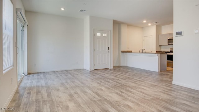 4229 Venus Falls Ave, North Las Vegas, NV 89084 - unfurnished living room with light wood-style flooring, recessed lighting, baseboards, and a sink