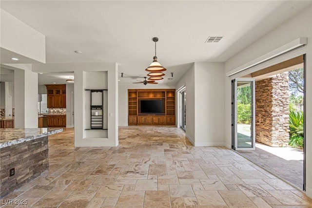 2436 Grassy Spring Pl, Las Vegas, NV 89135 - kitchen with stone tile flooring, a ceiling fan, light stone counters, hanging light fixtures, and open floor plan