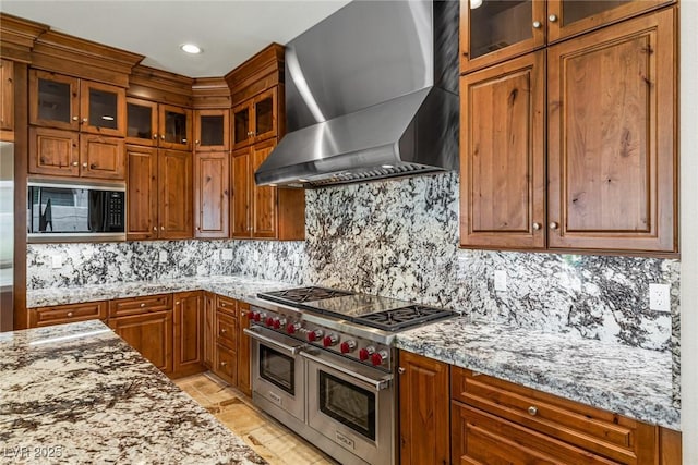 2436 Grassy Spring Pl, Las Vegas, NV 89135 - kitchen with wall chimney range hood, double oven range, black microwave, brown cabinets, and recessed lighting