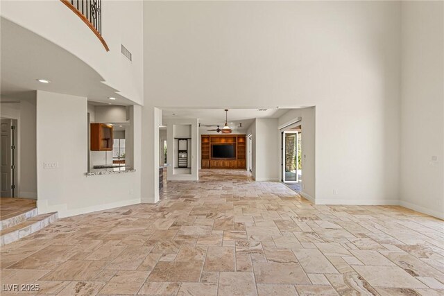 2436 Grassy Spring Pl, Las Vegas, NV 89135 - unfurnished living room with a high ceiling, stone tile flooring, and a ceiling fan