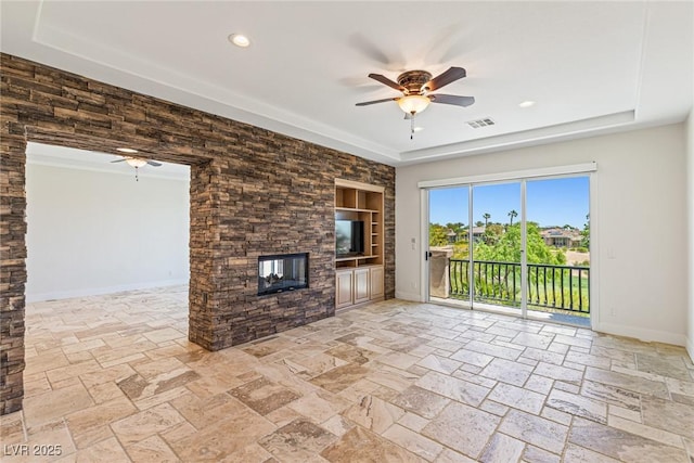 2436 Grassy Spring Pl, Las Vegas, NV 89135 - unfurnished living room featuring a ceiling fan, a tray ceiling, stone tile floors, and recessed lighting