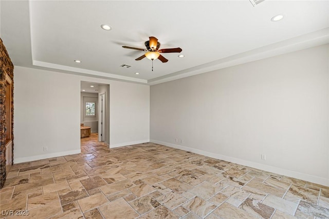 2436 Grassy Spring Pl, Las Vegas, NV 89135 - spare room featuring stone tile floors, a ceiling fan, a tray ceiling, and recessed lighting