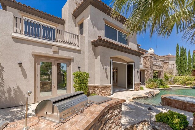 2436 Grassy Spring Pl, Las Vegas, NV 89135 - doorway to property with a balcony, french doors, exterior kitchen, an in-ground hot tub, and stucco siding