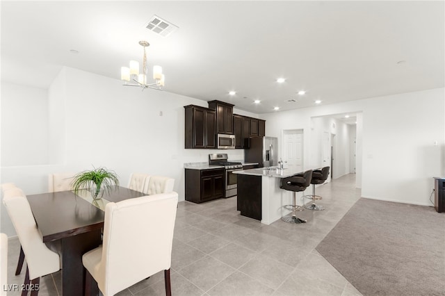 2495 Sunflower Days Ave Unit 2052, North Las Vegas, NV 89031 - kitchen featuring appliances with stainless steel finishes, a chandelier, a kitchen breakfast bar, dark brown cabinetry, and light tile patterned floors