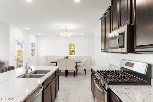 2495 Sunflower Days Ave Unit 2052, North Las Vegas, NV 89031 - kitchen featuring appliances with stainless steel finishes, a sink, a chandelier, light stone counters, and healthy amount of natural light
