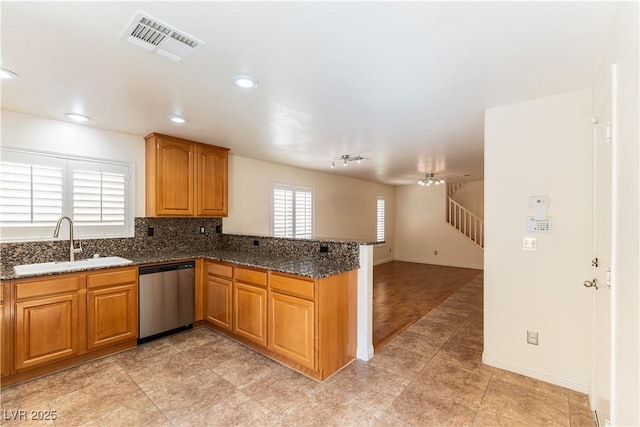 7923 Homer Ct, Las Vegas, NV 89139 - kitchen featuring dishwasher, a sink, a peninsula, dark stone counters, and open floor plan