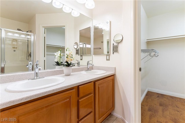 7923 Homer Ct, Las Vegas, NV 89139 - bathroom with a walk in closet, double vanity, an enclosed shower, and baseboards