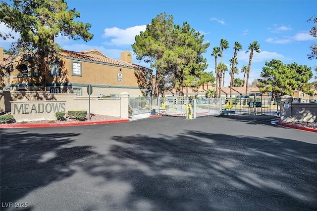 230 Mission Newport Ln Unit 104, Las Vegas, NV 89107 - view of asphalt street with a gate, a gated entry, a residential view, and curbs