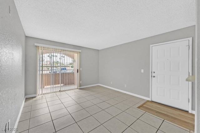 230 Mission Newport Ln Unit 104, Las Vegas, NV 89107 - unfurnished room featuring light tile patterned floors, a textured ceiling, and baseboards