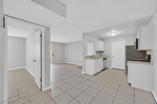 230 Mission Newport Ln Unit 104, Las Vegas, NV 89107 - kitchen with dishwasher, light tile patterned flooring, white cabinetry, baseboards, and light countertops