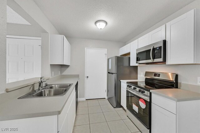 230 Mission Newport Ln Unit 104, Las Vegas, NV 89107 - kitchen featuring stainless steel appliances, a sink, a textured ceiling, white cabinets, and light countertops