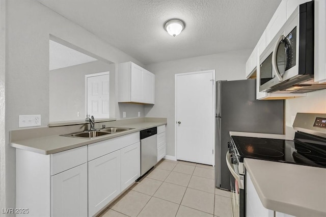 230 Mission Newport Ln Unit 104, Las Vegas, NV 89107 - kitchen with appliances with stainless steel finishes, a sink, a textured ceiling, white cabinetry, and light countertops