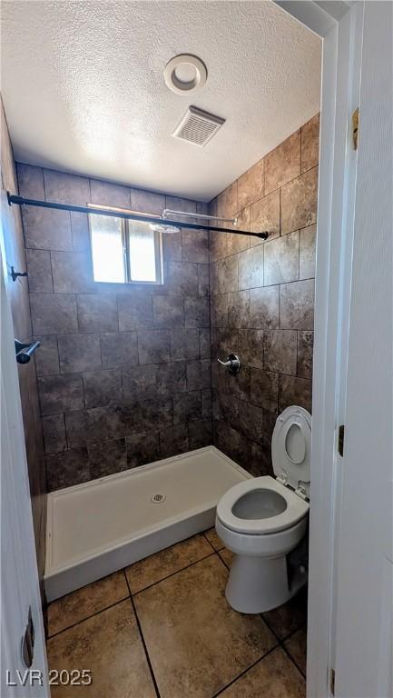 3020 Wilmington Way, Las Vegas, NV 89102 - bathroom featuring a textured ceiling, a stall shower, toilet, and tile patterned flooring