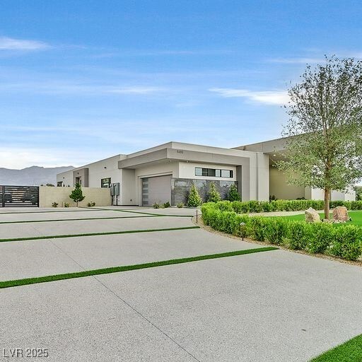 5400 Mello Ave, Las Vegas, NV 89131 - view of front facade with stucco siding, an attached garage, and concrete driveway