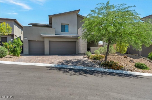 754 Tallgrass St, Las Vegas, NV 89138 - view of front of house featuring an attached garage, stucco siding, and decorative driveway