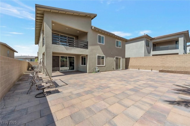 754 Tallgrass St, Las Vegas, NV 89138 - rear view of house featuring a balcony, a fenced backyard, stucco siding, and a patio