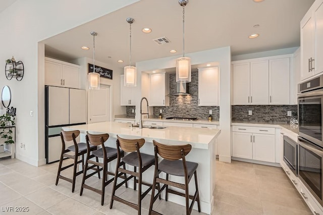 130 W Fairway Rd, Henderson, NV 89015 - kitchen featuring stainless steel appliances, a sink, tasteful backsplash, wall chimney exhaust hood, and light tile patterned floors