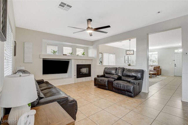 10988 Salernes St, Las Vegas, NV 89141 - living room with light tile patterned flooring, a ceiling fan, and a tiled fireplace