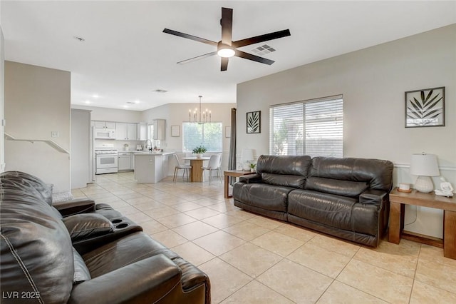 10988 Salernes St, Las Vegas, NV 89141 - living room featuring light tile patterned floors, a chandelier, and a ceiling fan