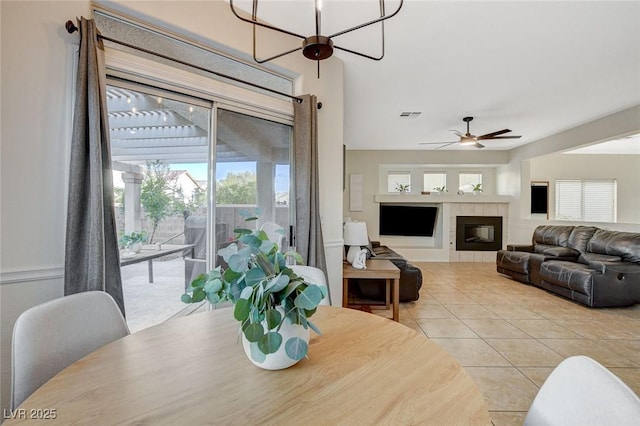 10988 Salernes St, Las Vegas, NV 89141 - dining room with ceiling fan, a tile fireplace, and tile patterned floors