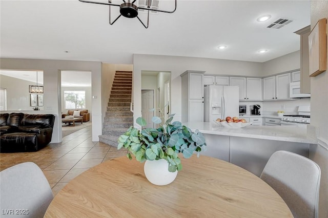10988 Salernes St, Las Vegas, NV 89141 - dining space with light tile patterned floors, stairway, recessed lighting, and a chandelier