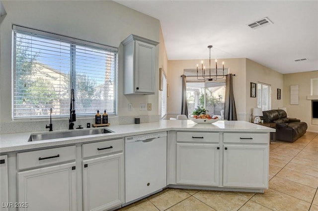 10988 Salernes St, Las Vegas, NV 89141 - kitchen featuring dishwasher, a sink, a peninsula, a chandelier, and light tile patterned flooring