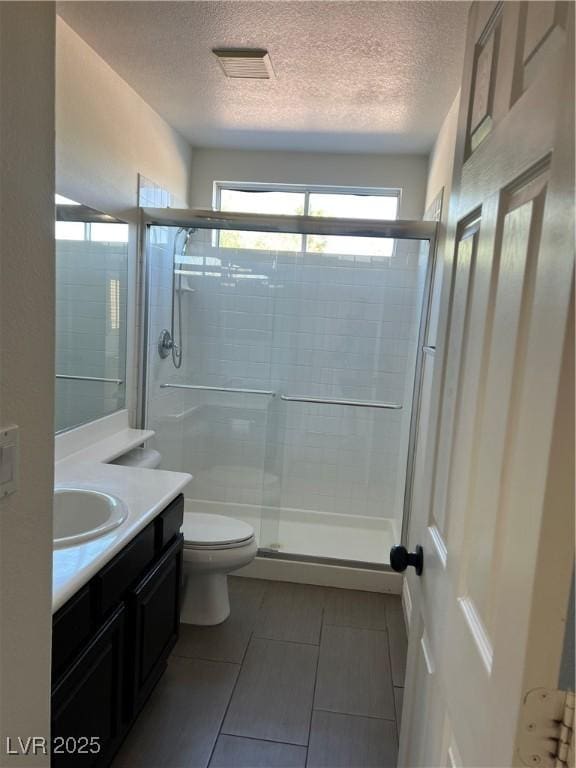 1921 Moonlight Bluff Ave, North Las Vegas, NV 89084 - bathroom with vanity, a textured ceiling, a stall shower, and tile patterned floors