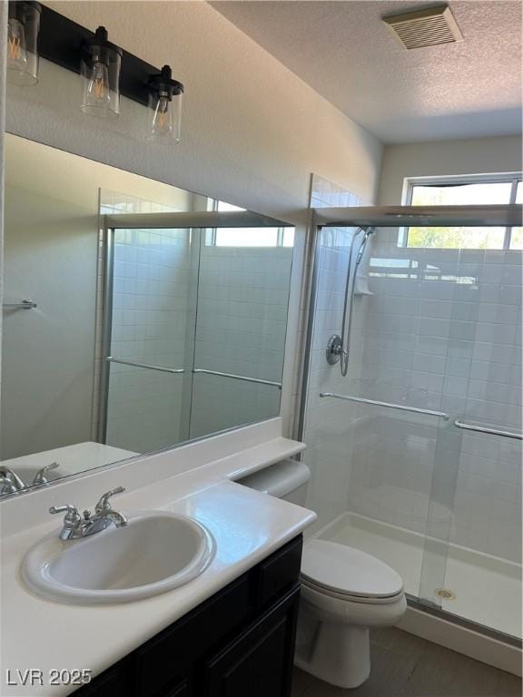 1921 Moonlight Bluff Ave, North Las Vegas, NV 89084 - full bath with a shower stall, a textured ceiling, vanity, and wood finished floors