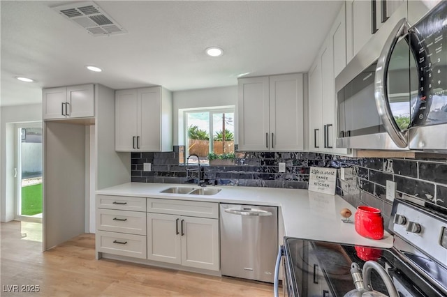 5200 Blanton Dr, Las Vegas, NV 89122 - kitchen featuring appliances with stainless steel finishes, a sink, light countertops, backsplash, and recessed lighting