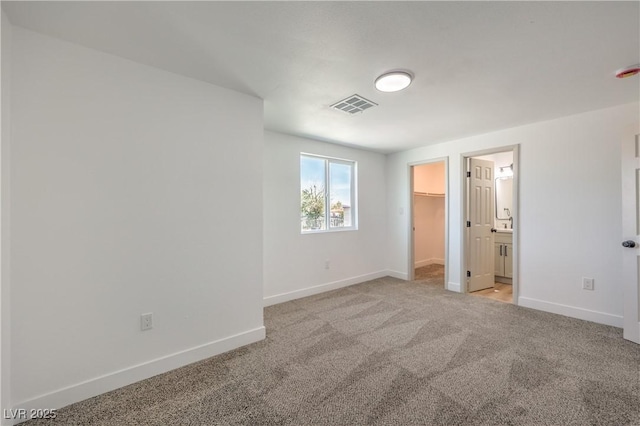5200 Blanton Dr, Las Vegas, NV 89122 - unfurnished bedroom with baseboards, a walk in closet, light colored carpet, ensuite bathroom, and a closet
