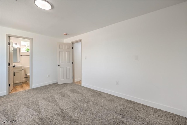 5200 Blanton Dr, Las Vegas, NV 89122 - unfurnished bedroom featuring light colored carpet, baseboards, and connected bathroom
