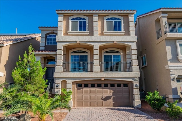 5889 Thistle Meadow Ave, Las Vegas, NV 89139 - view of front of home featuring stucco siding, driveway, a balcony, and a garage