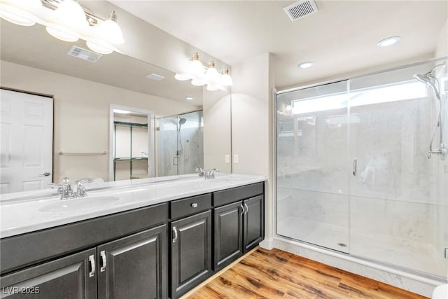 5889 Thistle Meadow Ave, Las Vegas, NV 89139 - bathroom with double vanity, wood finished floors, a stall shower, and recessed lighting