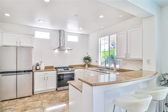 10667 Olympic Pine Dr, Las Vegas, NV 89135 - kitchen featuring appliances with stainless steel finishes, wall chimney range hood, a sink, white cabinets, and recessed lighting