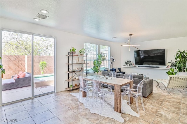 10667 Olympic Pine Dr, Las Vegas, NV 89135 - dining area with a textured ceiling, light tile patterned floors, and a chandelier