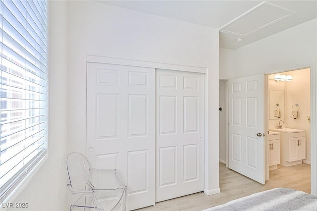 10667 Olympic Pine Dr, Las Vegas, NV 89135 - unfurnished bedroom with light wood-style flooring, a closet, a sink, baseboards, and attic access