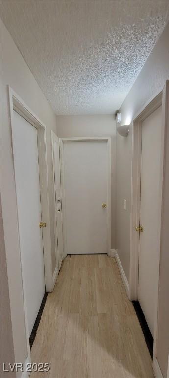 3151 Soaring Gulls Dr Unit 1074, Las Vegas, NV 89128 - hallway featuring light wood-type flooring, a textured ceiling, and baseboards