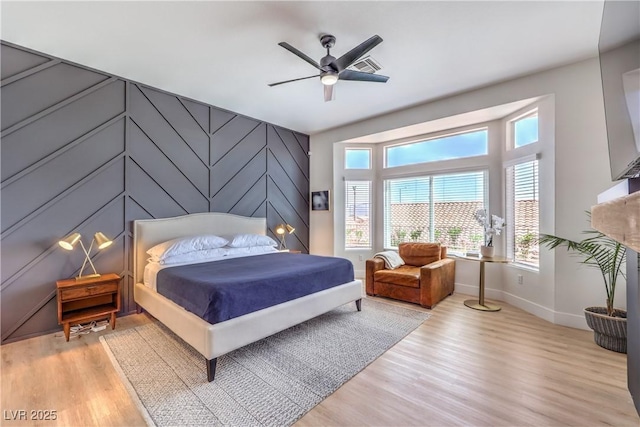 3028 Treesdale Dr, Las Vegas, NV 89134 - bedroom featuring baseboards, light wood-type flooring, an accent wall, and ceiling fan