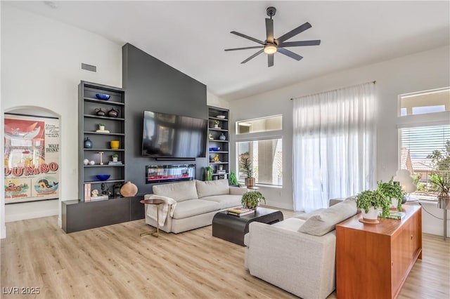 3028 Treesdale Dr, Las Vegas, NV 89134 - living room featuring a ceiling fan, light wood finished floors, built in shelves, and high vaulted ceiling