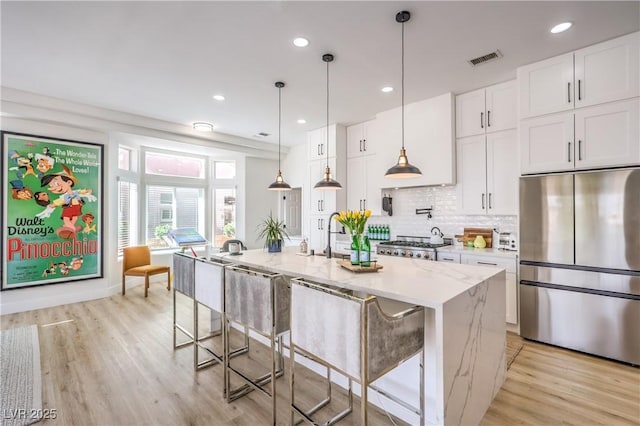 3028 Treesdale Dr, Las Vegas, NV 89134 - kitchen featuring stainless steel refrigerator, white cabinets, light wood-type flooring, backsplash, and recessed lighting