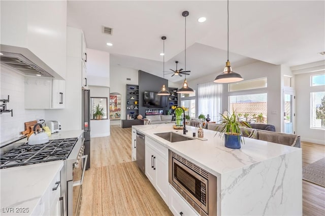 3028 Treesdale Dr, Las Vegas, NV 89134 - kitchen with open floor plan, appliances with stainless steel finishes, wall chimney exhaust hood, a sink, and a kitchen island with sink