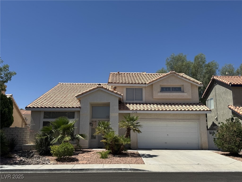 1745 Walingwood Dr, North Las Vegas, NV 89031 - mediterranean / spanish-style house featuring concrete driveway, stucco siding, a tiled roof, and an attached garage