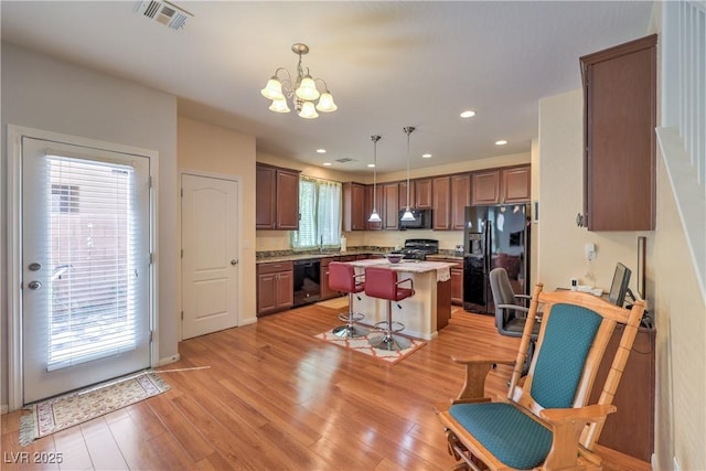 10353 Yew Blossom Ave, Las Vegas, NV 89166 - kitchen with black appliances, a center island, a chandelier, a sink, and light countertops