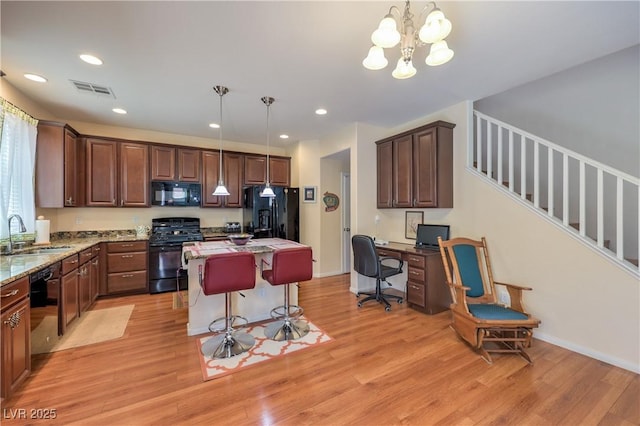 10353 Yew Blossom Ave, Las Vegas, NV 89166 - kitchen with black appliances, a sink, light wood-style flooring, a center island, and hanging light fixtures